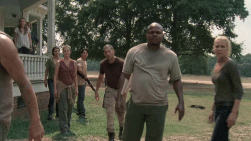 A Group Of People Standing In Front Of A House In A Field GIF
