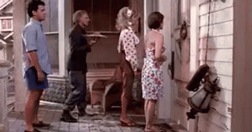 A Group Of People Standing In Front Of A House . GIF