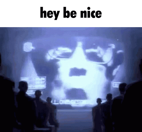 A Group Of People Standing In Front Of A Large Screen That Says Hey Be Nice GIF