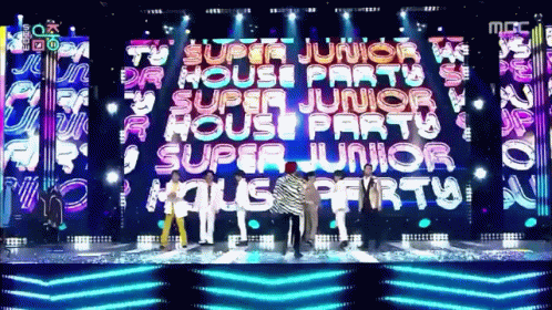 A Group Of People Standing In Front Of A Large Screen That Says " Super Junior House Party " GIF