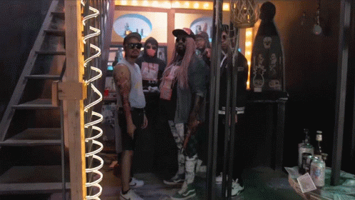 A Group Of People Standing In Front Of A Neon Sign That Says ' Aa ' GIF