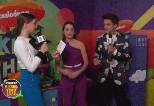 A Group Of People Standing In Front Of A Nickelodeon Logo GIF