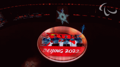 Group Standing In Front Of Beijing 2022 Screen GIF