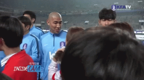 A Group Of People Standing In Front Of A Screen That Says Kfatv GIF