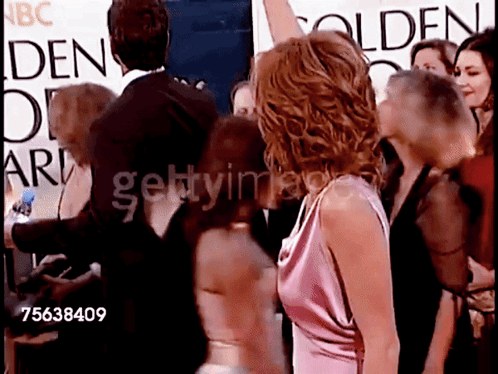 a group of people standing in front of a sign that says golden globe awards