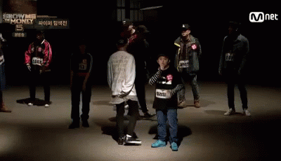 A Group Of People Standing In Front Of A Sign That Says ' Show Me The Money ' GIF