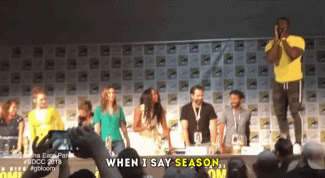 A Group Of People Standing In Front Of A Sign That Says When I Say Season On It GIF