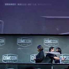 A Group Of People Standing In Front Of A Wall That Says Comic Con Paris GIF
