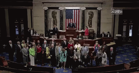 A Group Of People Standing In Front Of An American Flag With A Sign That Says Nightly Fn News GIF