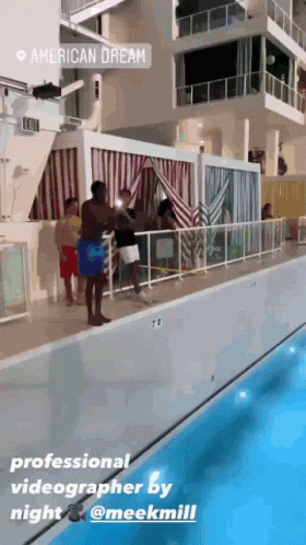 A Group Of People Standing Next To A Swimming Pool With A Sign That Says American Dream On It GIF