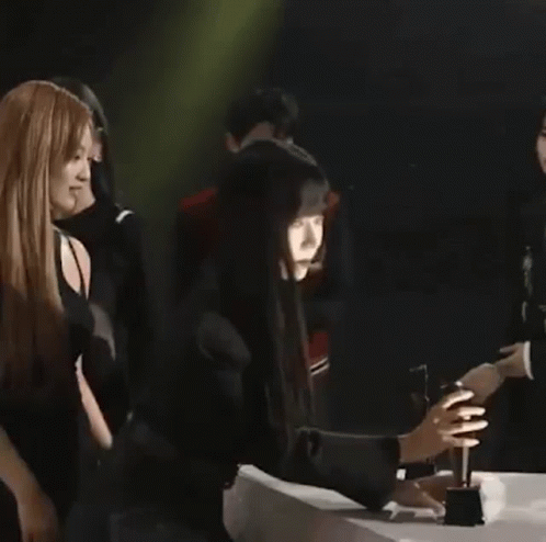 A Group Of People Standing Next To Each Other On A Stage . GIF