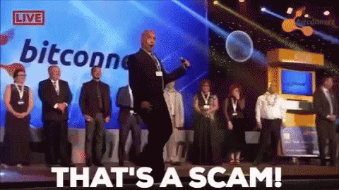 A Group Of People Standing On A Stage With The Words That 'S A Scam On The Screen Behind Them GIF
