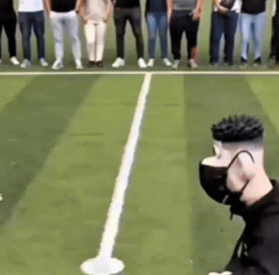 A Group Of People Standing On A Tennis Court With A Person Wearing A Mask GIF