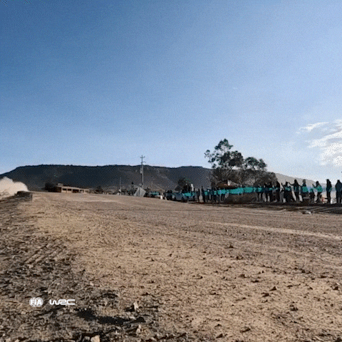 A Group Of People Standing On The Side Of A Dirt Road With The Word Fia On The Bottom Right GIF