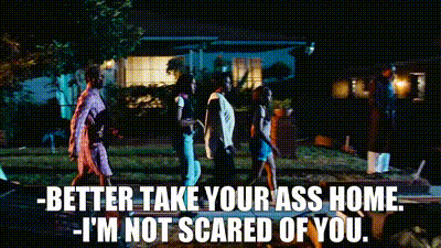 A Group Of People Walking In Front Of A House At Night With The Words Better Take Your Ass Home I 'M Not Scared Of You GIF