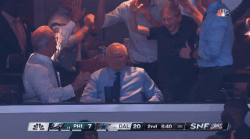 A Group Of People Watching A Game With A Scoreboard That Says Phil 7 Dal 20 GIF