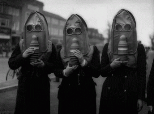 A Group Of People Wearing Gas Masks Are Standing In A Line GIF