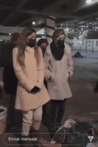 A Group Of People Wearing Masks Are Standing In Front Of A Sign That Says Enviar Mensaje GIF