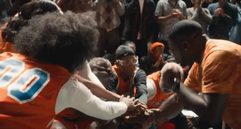 a group of people wearing orange jerseys with the number 80 on them