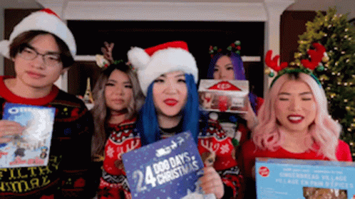 A Group Of People Wearing Santa Hats And Sweaters Are Holding Christmas Presents . GIF