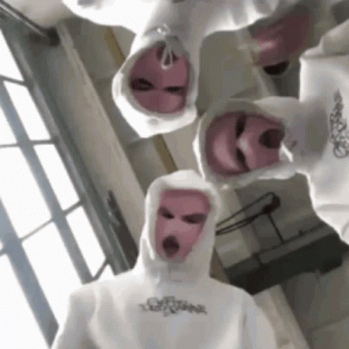 A Group Of People Wearing White Hoodies And Pink Ski Masks . GIF