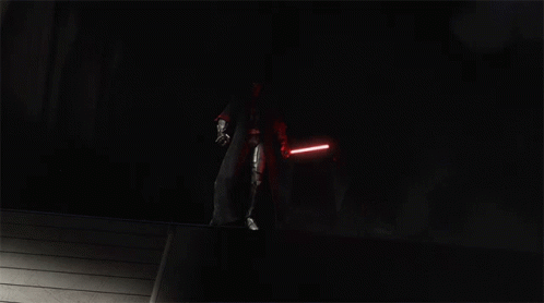 A Group Of People With Red Lightsabers In The Dark GIF