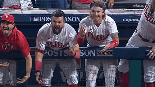 A Group Of Philadelphia Phillies Baseball Players Standing Behind A Dugout GIF