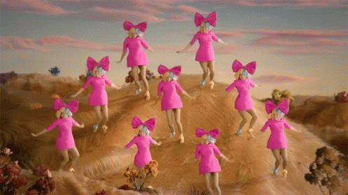 A Group Of Pink Dolls With Bows On Their Heads Are Dancing On A Hill GIF