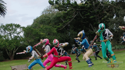A Group Of Power Rangers In A Park GIF