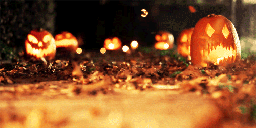 A Group Of Pumpkins With Faces Carved Into Them Are Lit Up In The Dark GIF