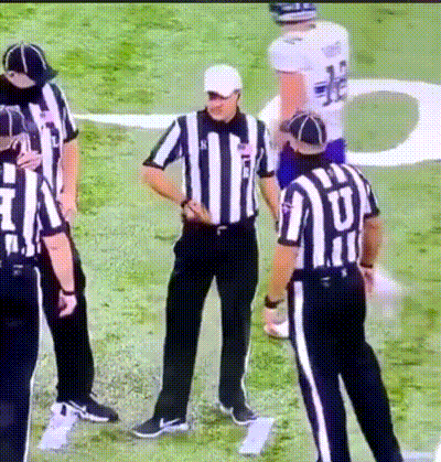 A Group Of Referees Standing On A Field With One Wearing A Jersey That Says ' U ' On It GIF