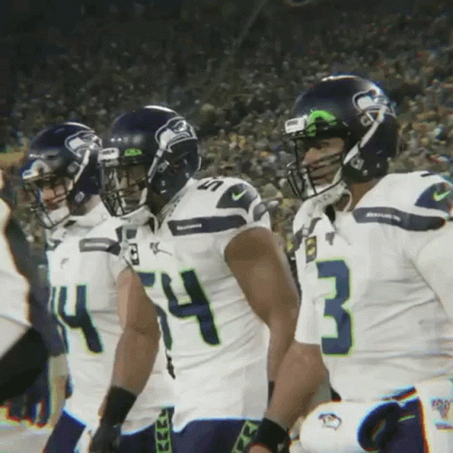 A Group Of Seahawks Football Players Standing In A Line GIF