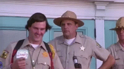 A Group Of Sheriffs Are Standing In Front Of A Building . GIF