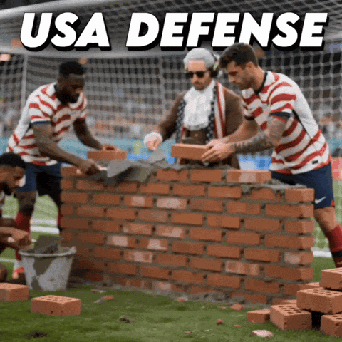 A Group Of Soccer Players Are Building A Wall With Bricks And The Words Usa Defense Above Them GIF
