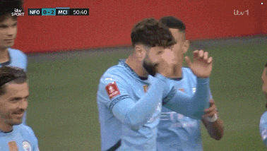 a group of soccer players are celebrating a goal during a game sponsored by itv sport