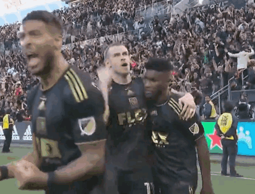A Group Of Soccer Players Are Celebrating A Goal On A Field . GIF