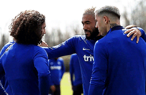 A Group Of Soccer Players Are Huddled Together And One Of Their Shirts Says Triv GIF