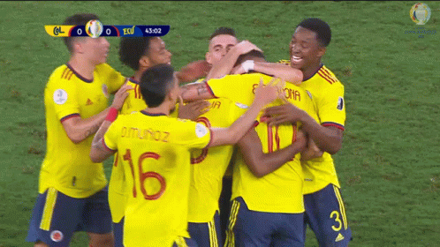 a group of soccer players are hugging each other and one of them has the number 16 on his back