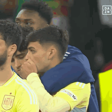 A Group Of Soccer Players Are Hugging Each Other With A Da Zn Logo In The Background GIF