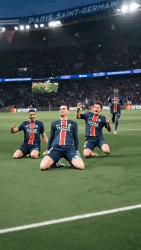 a group of soccer players are kneeling on the field in front of a crowd .