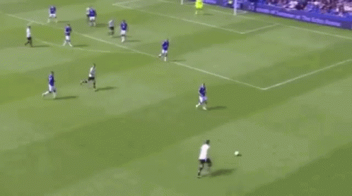 A Group Of Soccer Players Are Playing A Game On A Field With A Crowd Watching . GIF