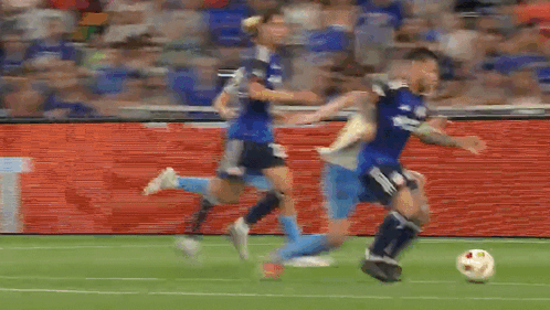A Group Of Soccer Players Are Playing A Game On A Soccer Field . GIF