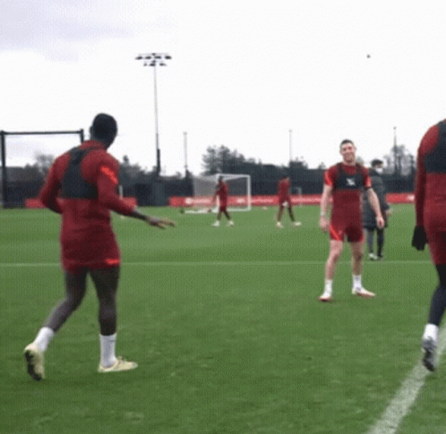 A Group Of Soccer Players Are Playing On A Field And One Of Them Is Wearing A Jersey That Says ' Liverpool ' GIF