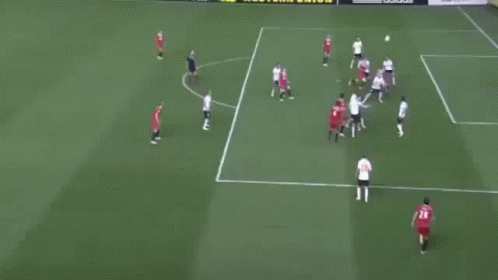 A Group Of Soccer Players Are Playing On A Field With A Goalie In A Blue Uniform GIF