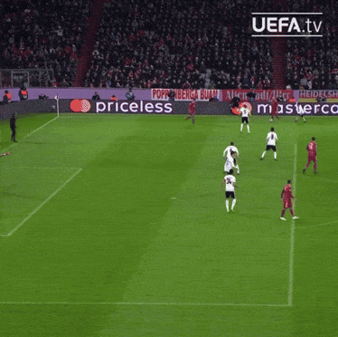 a group of soccer players are playing on a field with a ps4 ad in the background