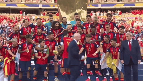 A Group Of Soccer Players Are Posing For A Picture With A Man In A Suit With The Number 20 On His Shirt GIF
