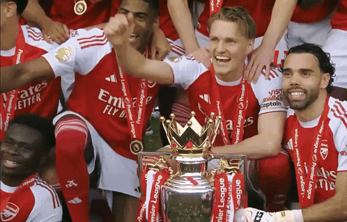 A Group Of Soccer Players Are Posing For A Picture With A Trophy That Says Premier League On It GIF