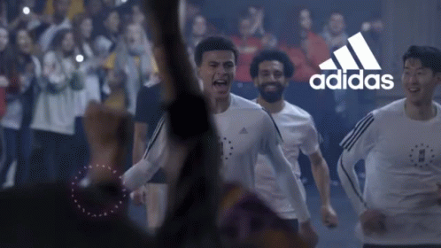 A Group Of Soccer Players Are Running In Front Of A Crowd With The Adidas Logo In The Background GIF