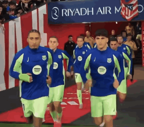 A Group Of Soccer Players Are Running In Front Of A Riyadh Air Logo GIF