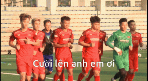 A Group Of Soccer Players Are Running On A Field With The Words Cuoi Len Anh Em Oi Written In White GIF
